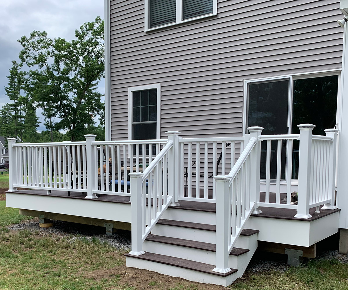 Outdoor deck featuring white railing and steps.