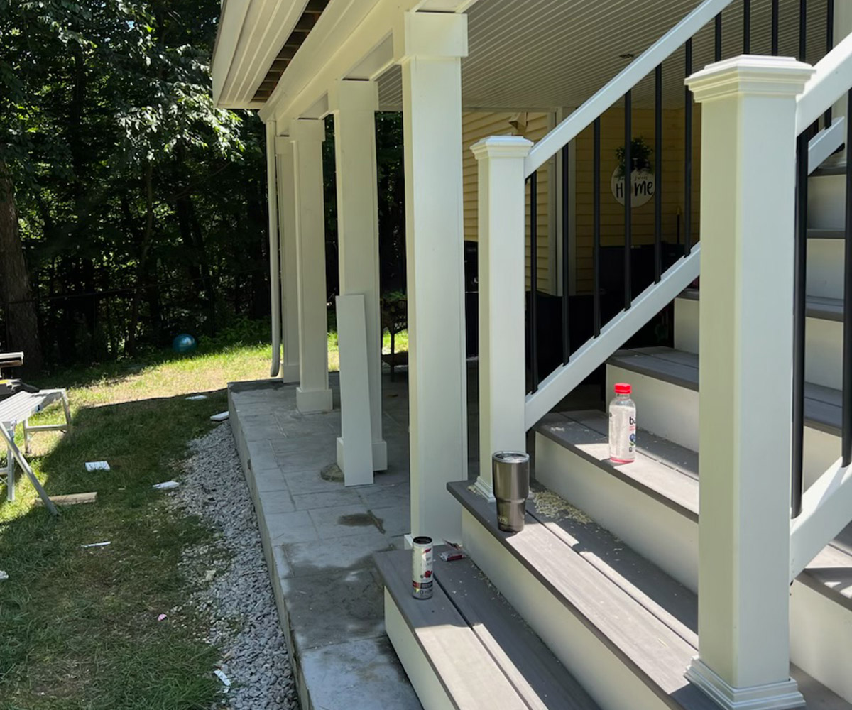 Outdoor entrance with white railing on porch.